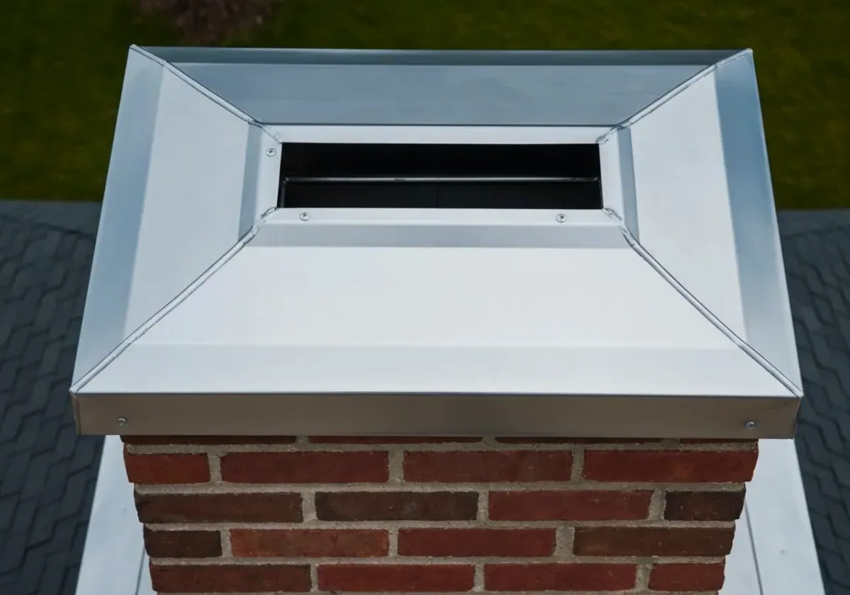 After — chimney cap installation: A wide-open flue capped in stainless — the rain and the squirrels stay out.