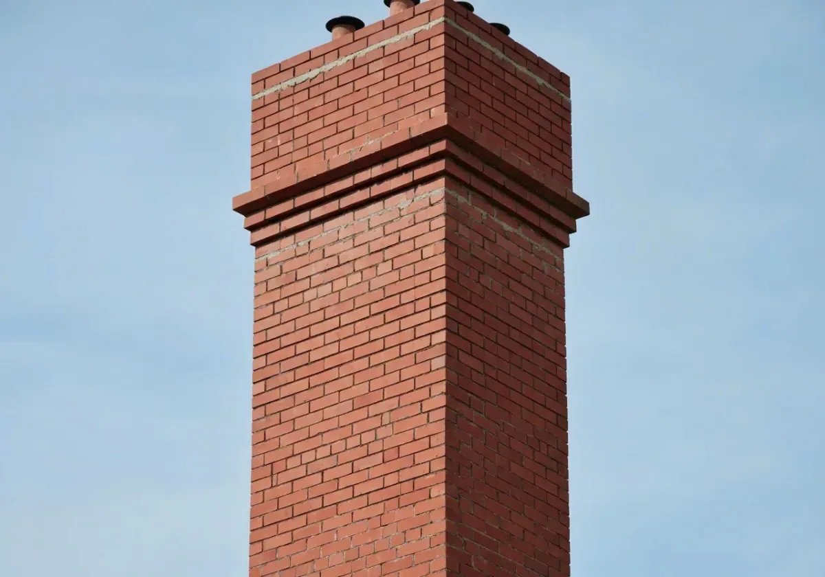 After — chimney repair: Spalled brick and washed-out mortar rebuilt into a tight, weatherproof stack.